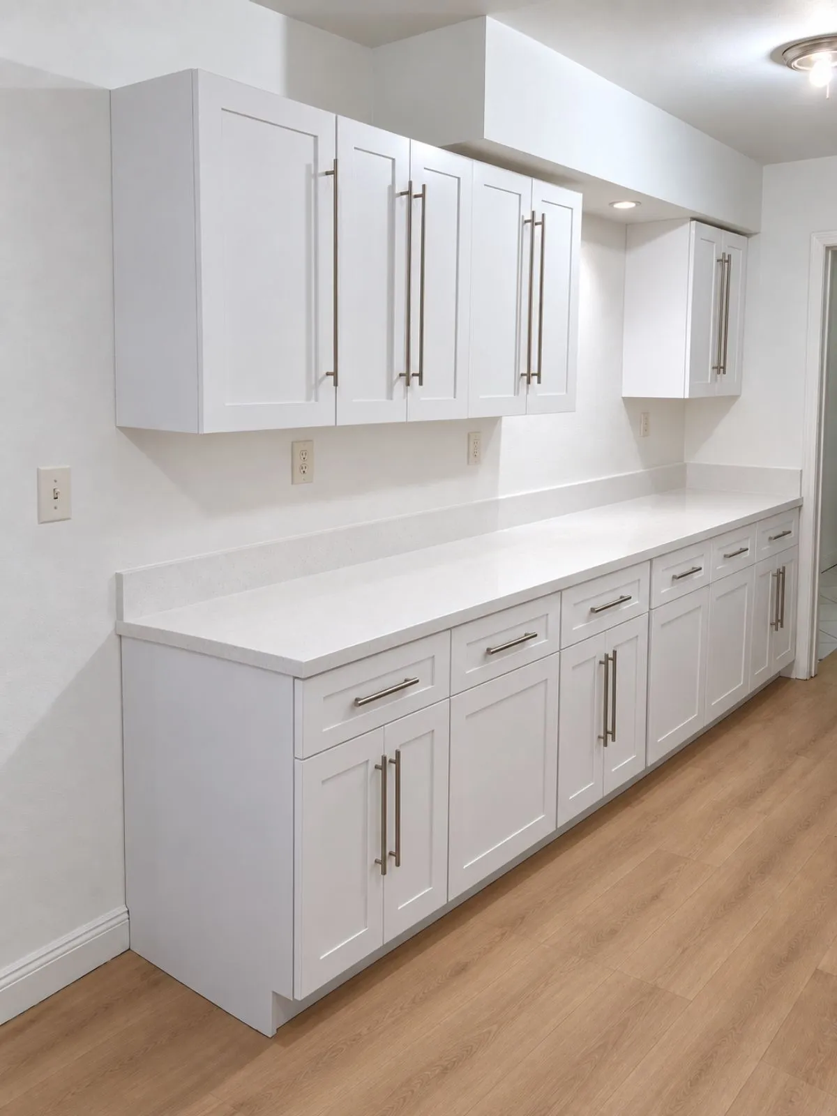 The same room with white cabinets and a countertop installed