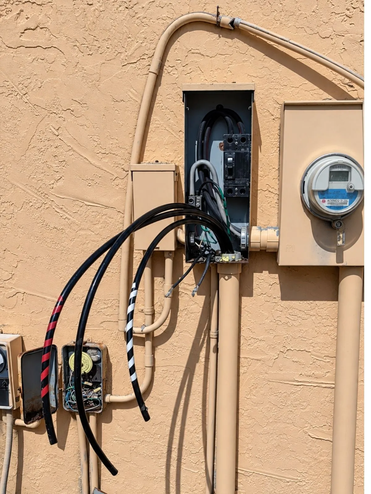 Exterior electrical panel area with loose, exposed wiring